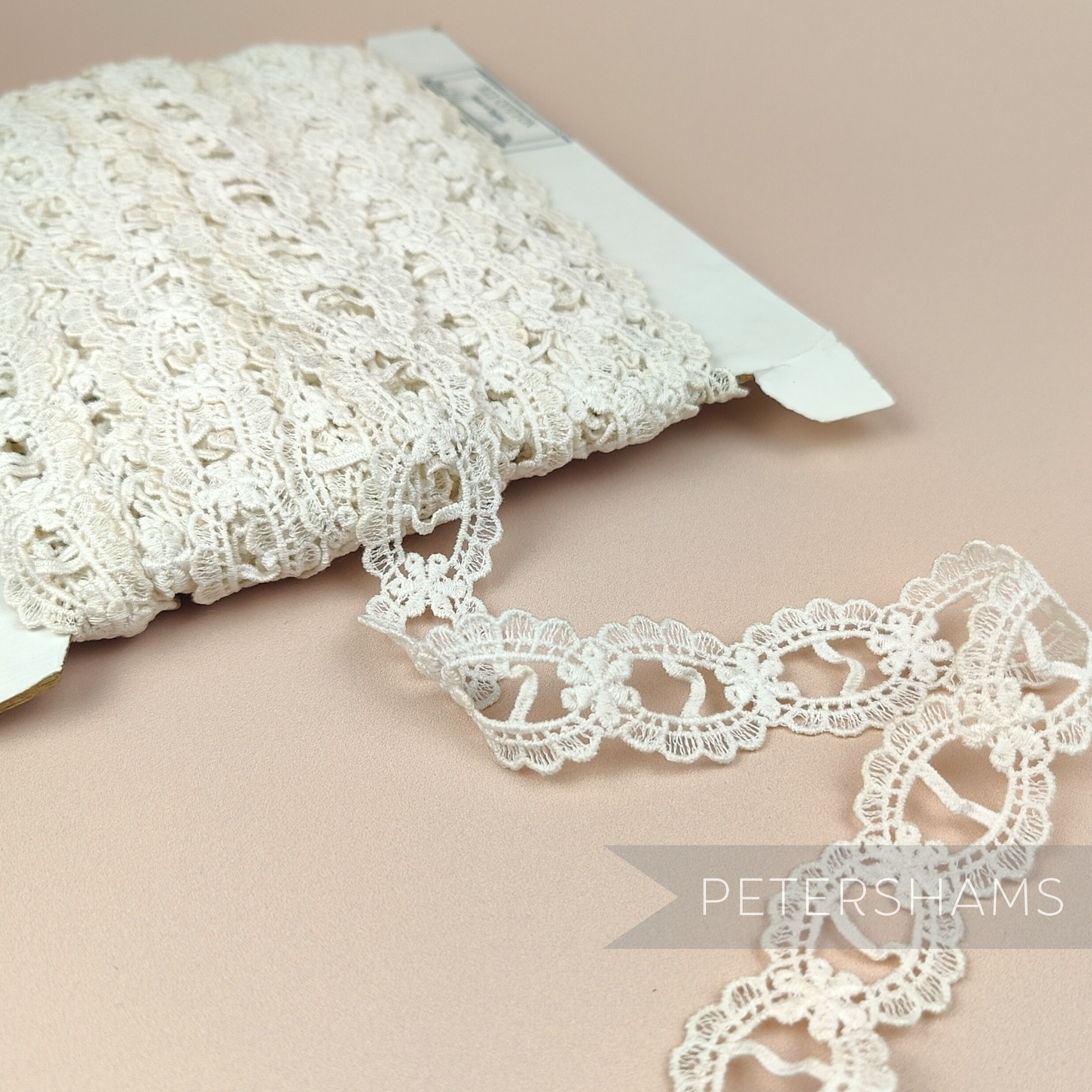 Petershams Millinery Supplies vintage ivory cotton guipure ribbon slot lace with a scalloped frame design.
