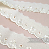 Petershams Millinery Supplies 25mm deep ivory broderie anglaise lace trim with floral cut-outs and scalloped edges.