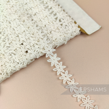 Petershams Millinery Supplies vintage 1940s ivory cotton guipure lace trim with a delicate pointed flower design.