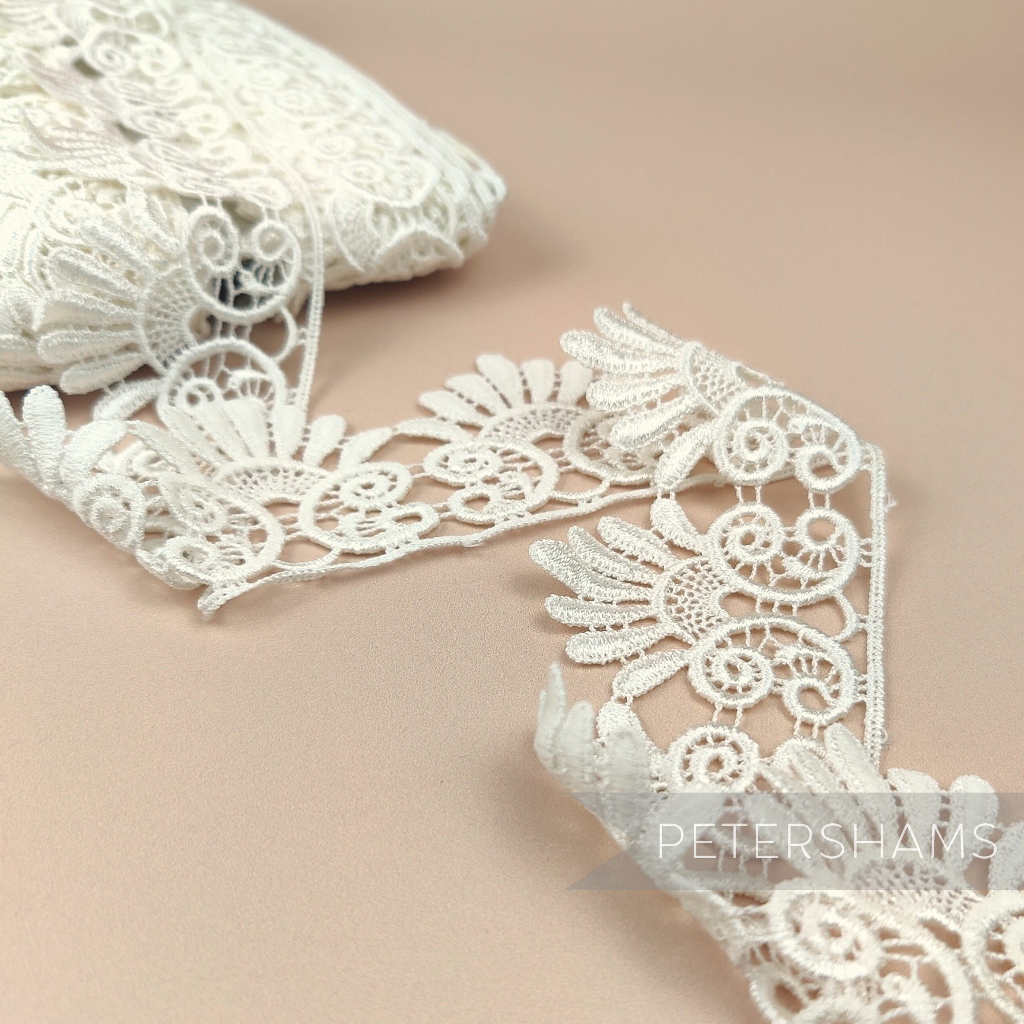 Petershams Millinery Supplies 6cm ivory guipure lace trim with a vintage filigree design for bridal sewing projects.
