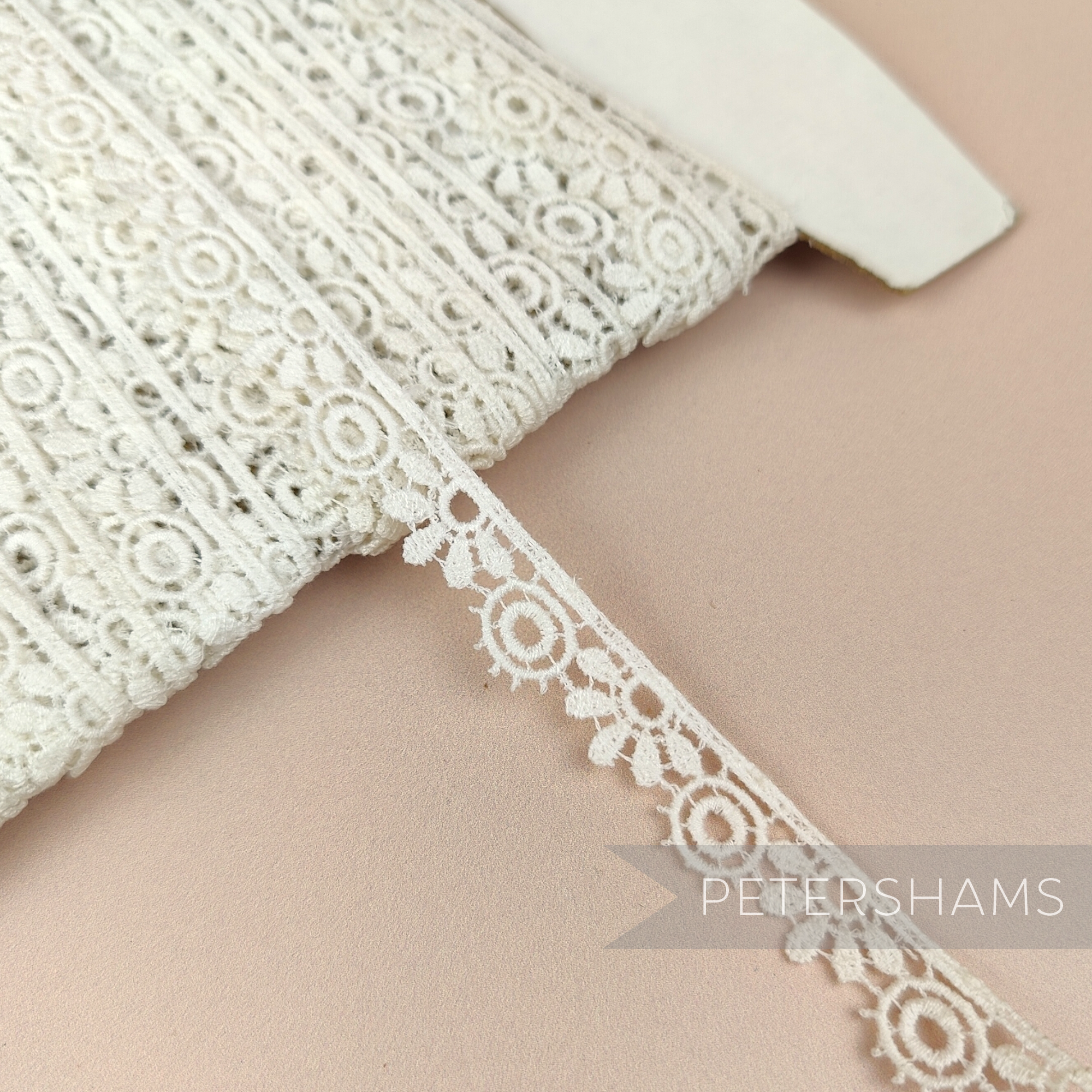 Petershams Millinery Supplies vintage ivory guipure lace trim with a 12mm daisy and leaf pattern on a spool.