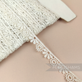 Petershams Millinery Supplies vintage ivory guipure lace trim with a 12mm daisy and leaf pattern on a spool.