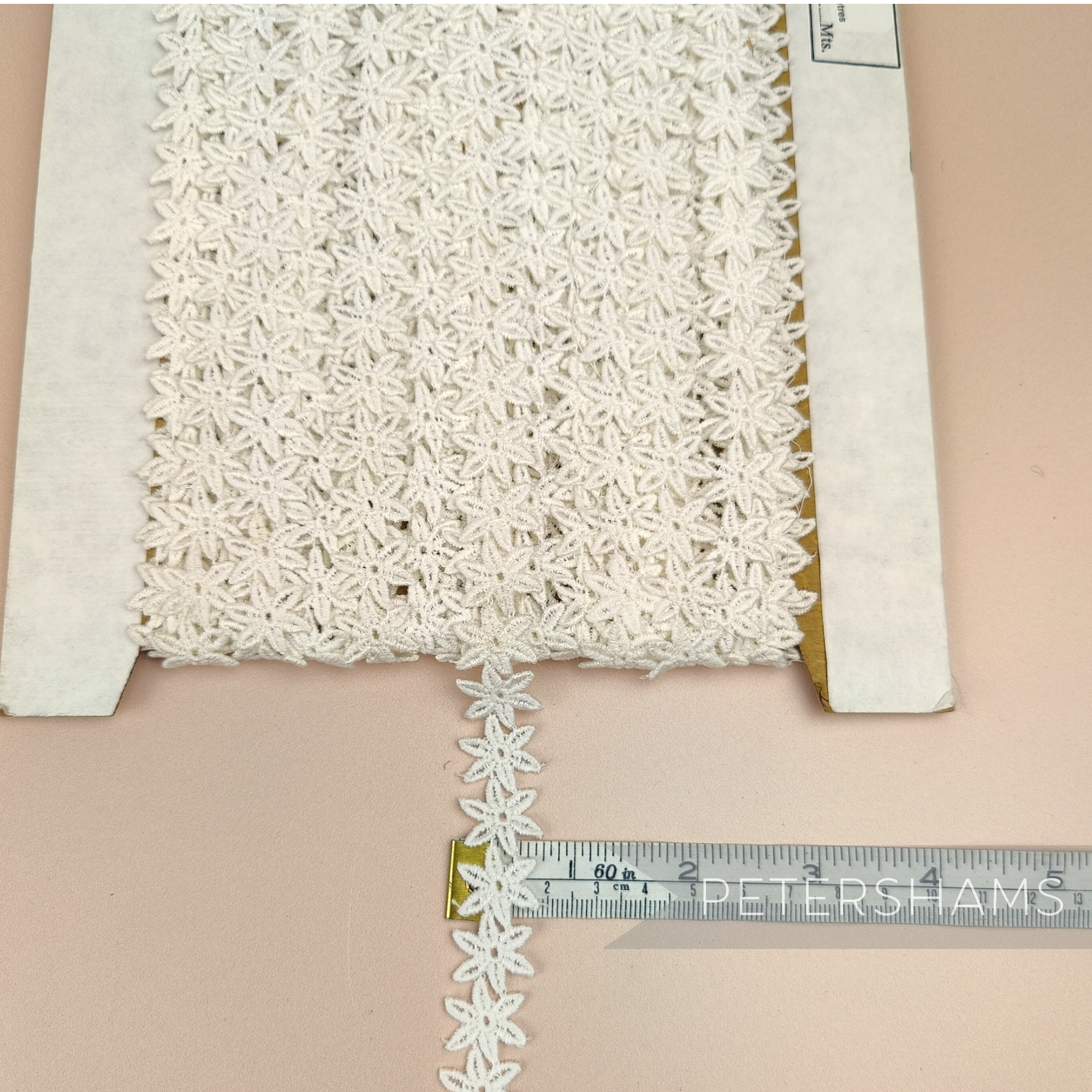 Petershams Millinery Supplies vintage 1940s ivory cotton guipure lace trim with a delicate pointed flower design.