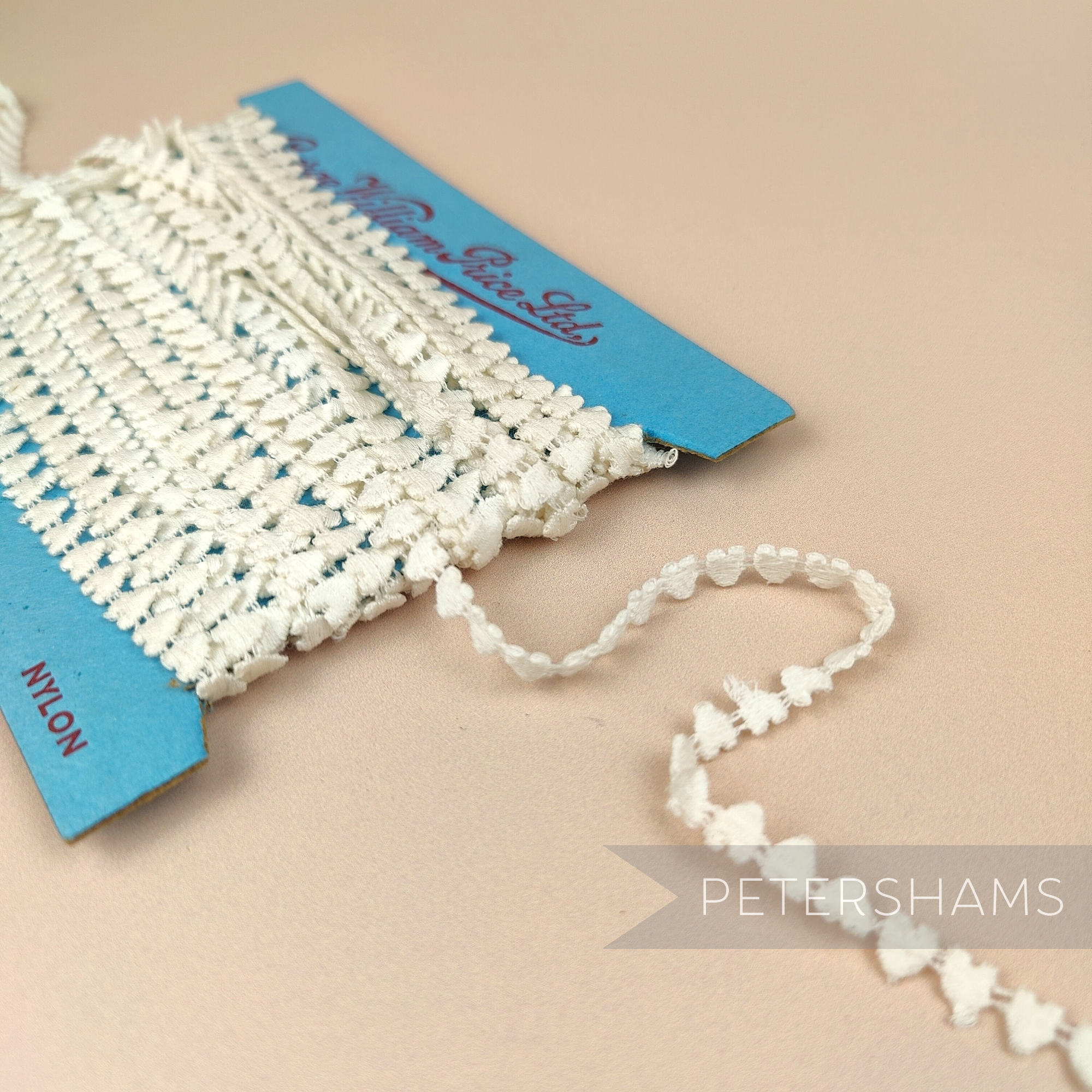 Petershams Millinery Supplies vintage 7mm ivory heart guipure lace trim on a blue card