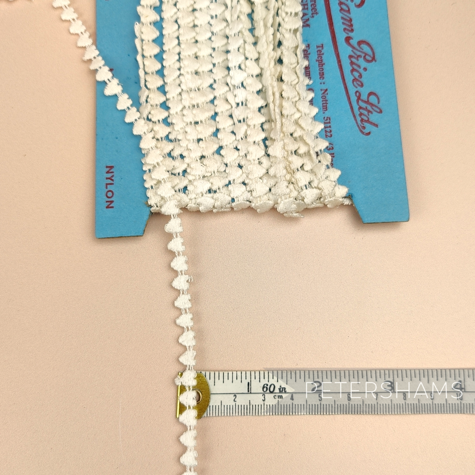 Petershams Millinery Supplies vintage 1950s ivory heart guipure lace trim measuring 7mm wide on a display card.