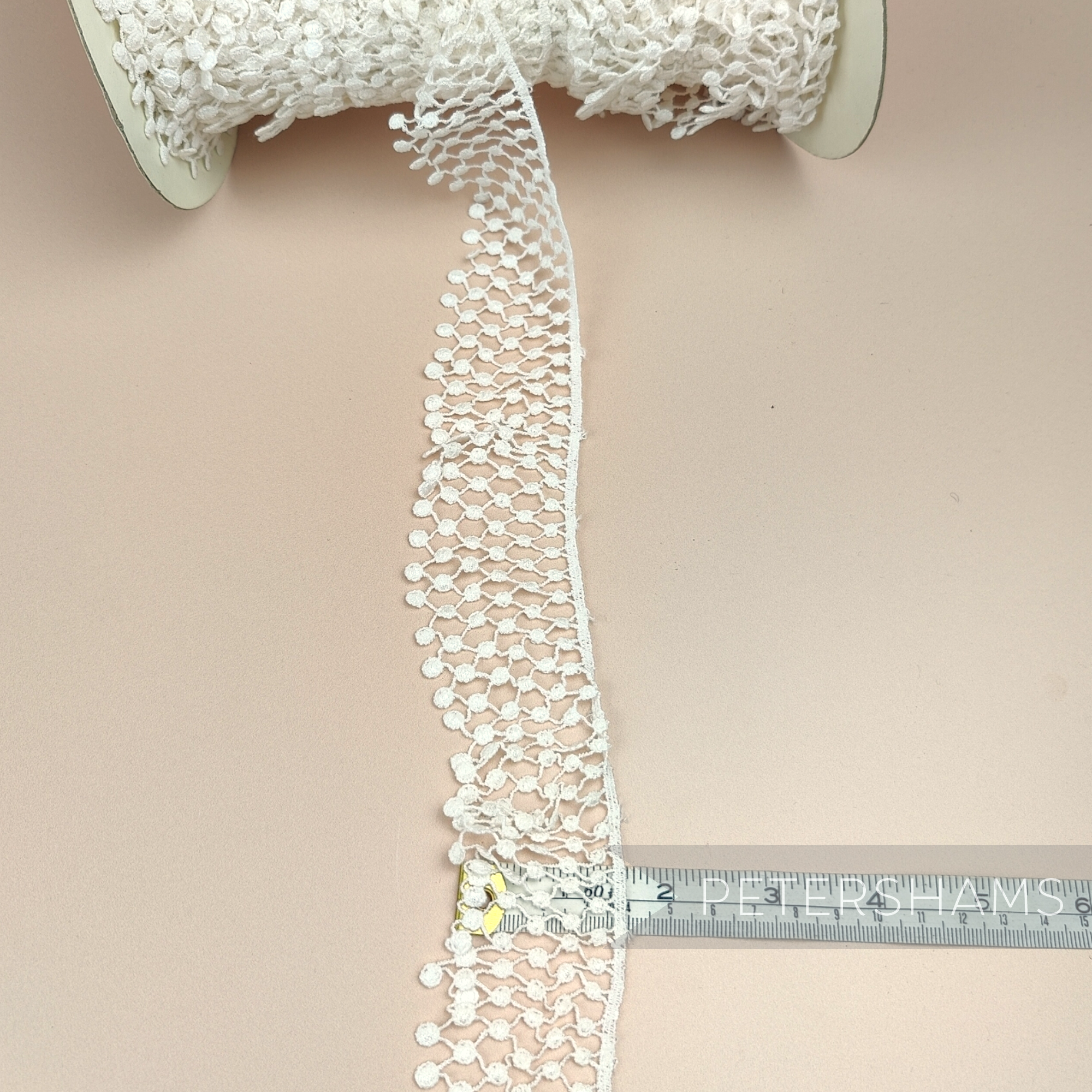 Petershams Millinery Supplies vintage ivory nylon guipure lace trim with a 40mm thatched ruffle design on a spool.