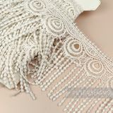 Petershams Millinery Supplies vintage 1990s ivory guipure lace trim with a wide peacock feather design and fringe.