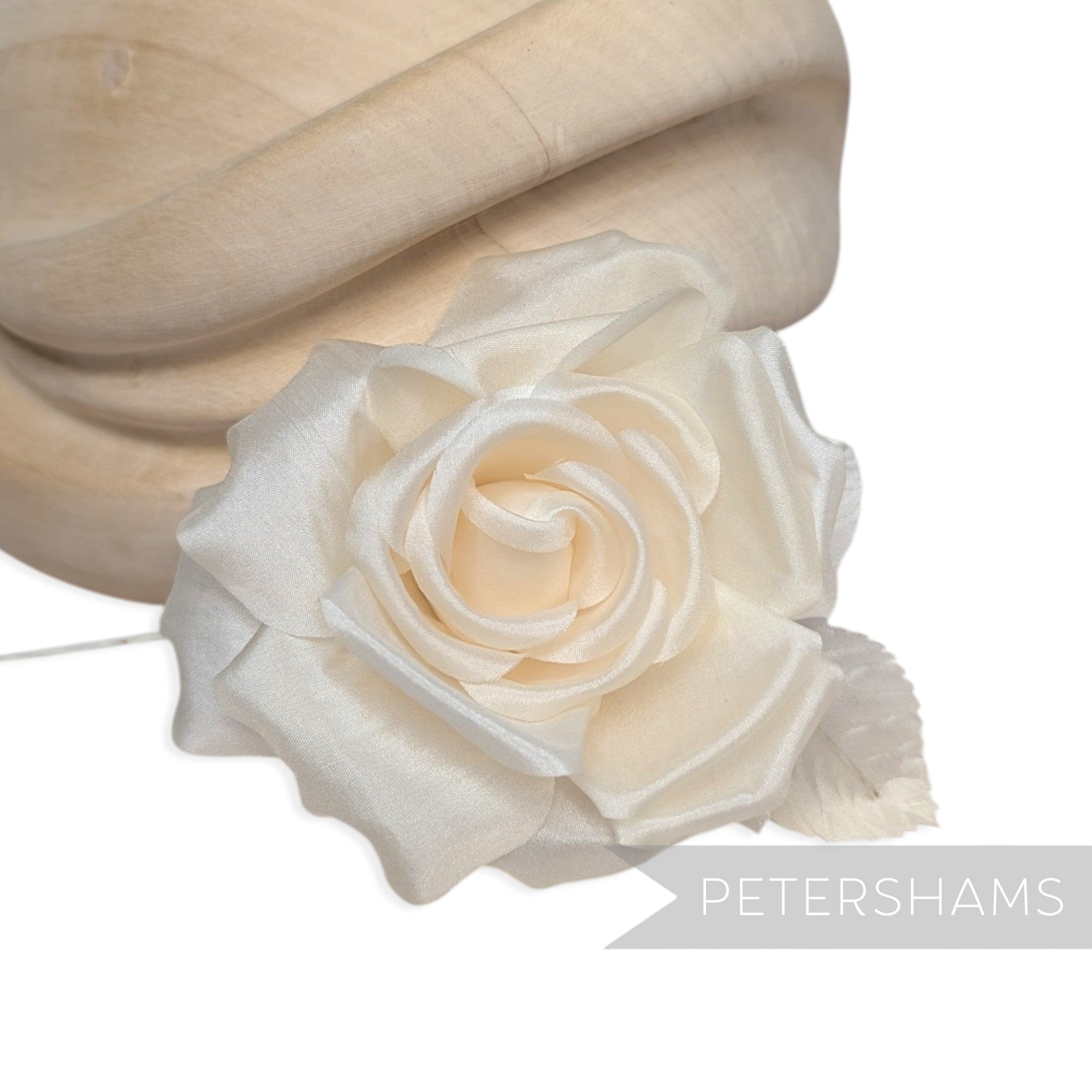 Petershams Millinery Supplies Kullie petite cream silk hat flower with curled petals and silk leaves on a wire stem.