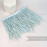 Petershams Millinery Supplies extra long pale blue goose biot feather fringe on a white satin ribbon binding.