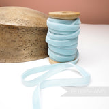 Petershams Millinery Supplies 10mm light blue vintage velvet ribbon on a wooden spool next to a millinery block.