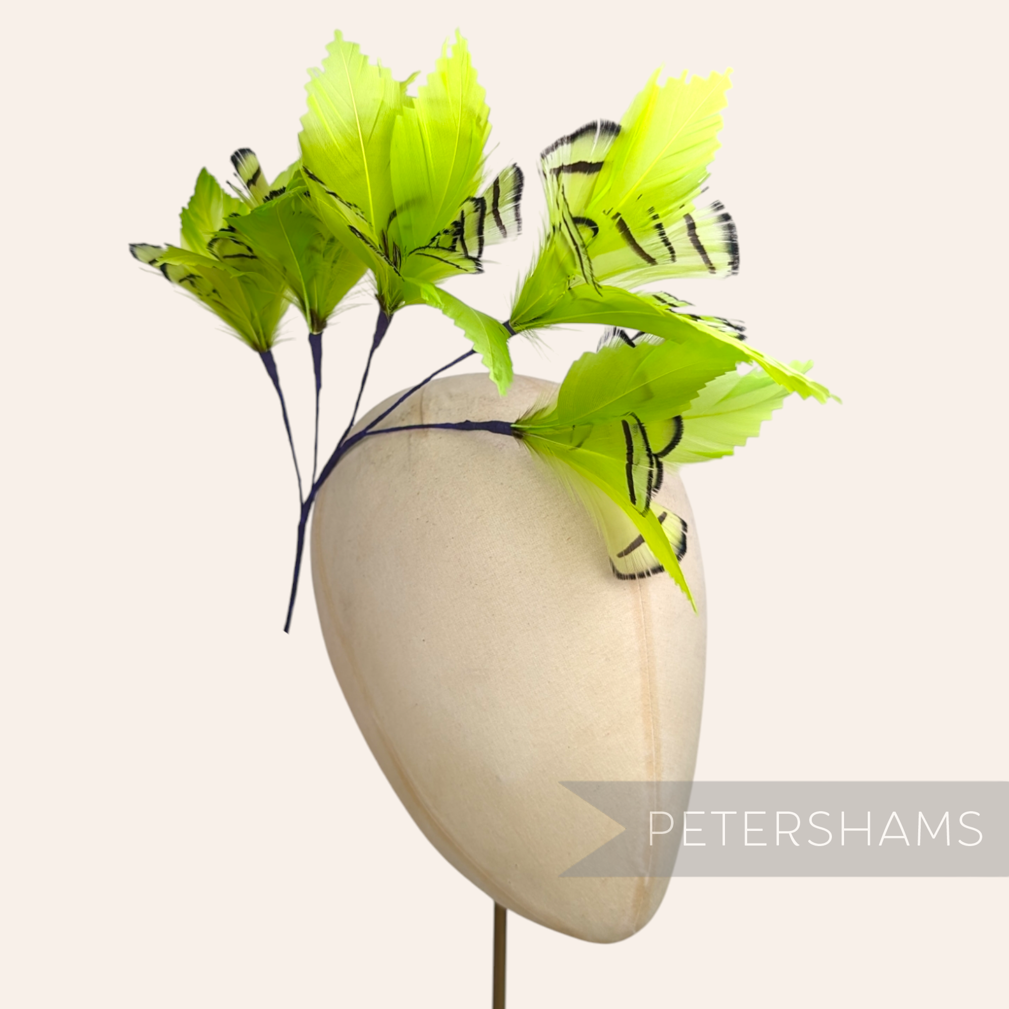 Petershams Millinery Supplies lime green Lady Amherst and goose feather flower hat mount on a millinery head block.