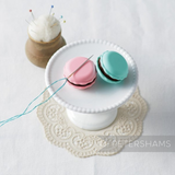 Petershams Millinery Supplies Clover macaron needle minders in raspberry pink and pistachio green on a white stand