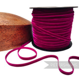 Petershams Millinery Supplies 7mm magenta French velvet ribbon on a spool next to a wooden millinery block