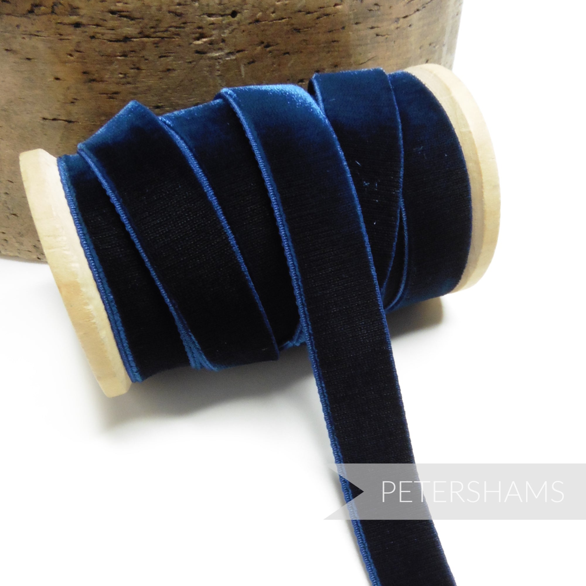 Petershams Millinery Supplies 16mm navy blue elastic stretch velvet ribbon on a wooden spool for millinery projects.