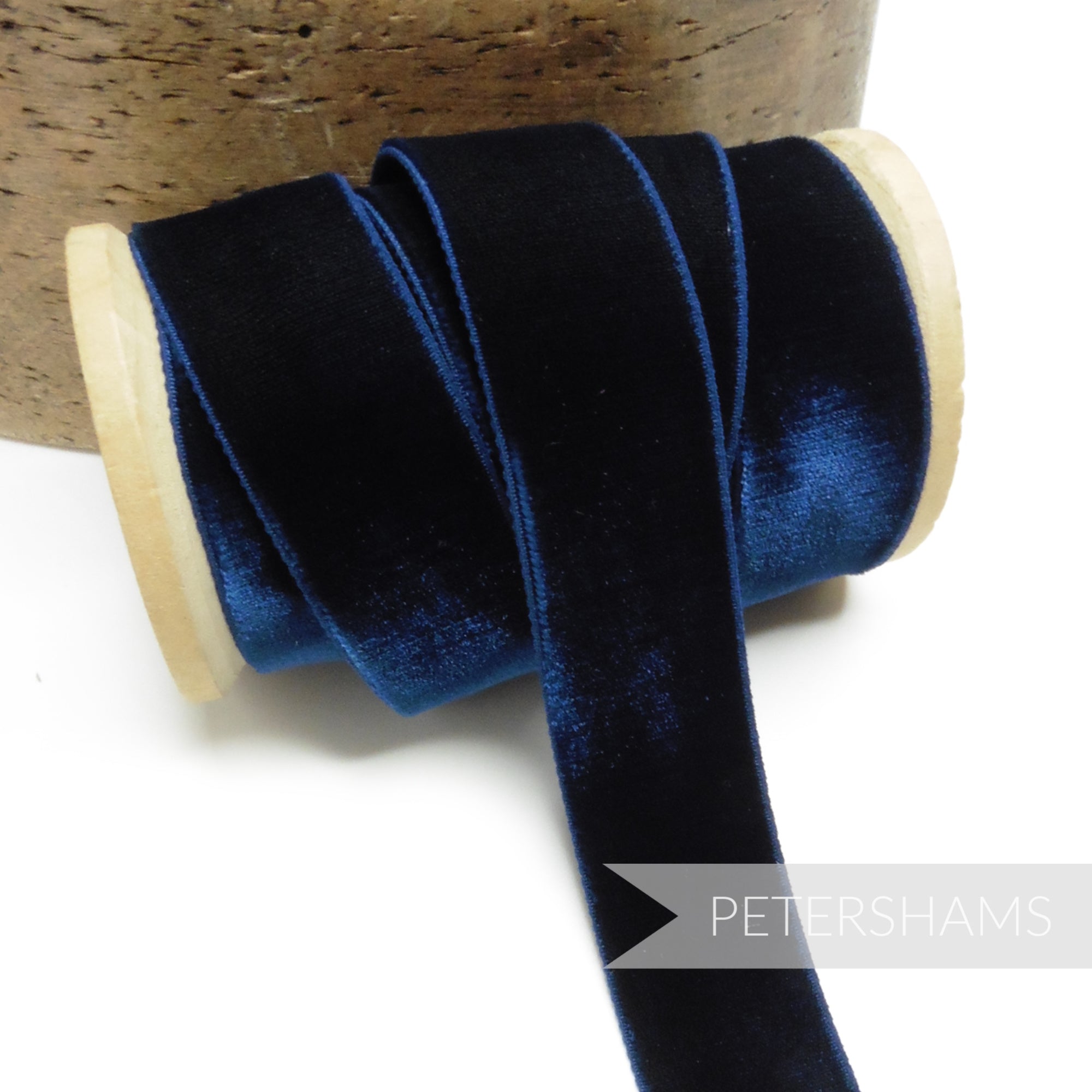 Petershams Millinery Supplies 23mm navy blue elastic velvet ribbon on a wooden spool for millinery and craft projects.