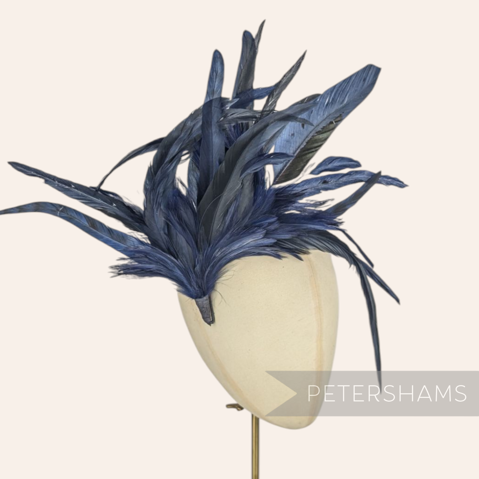 Petershams Millinery Supplies extra large navy blue coque and hackle feather hat mount on a millinery head form.