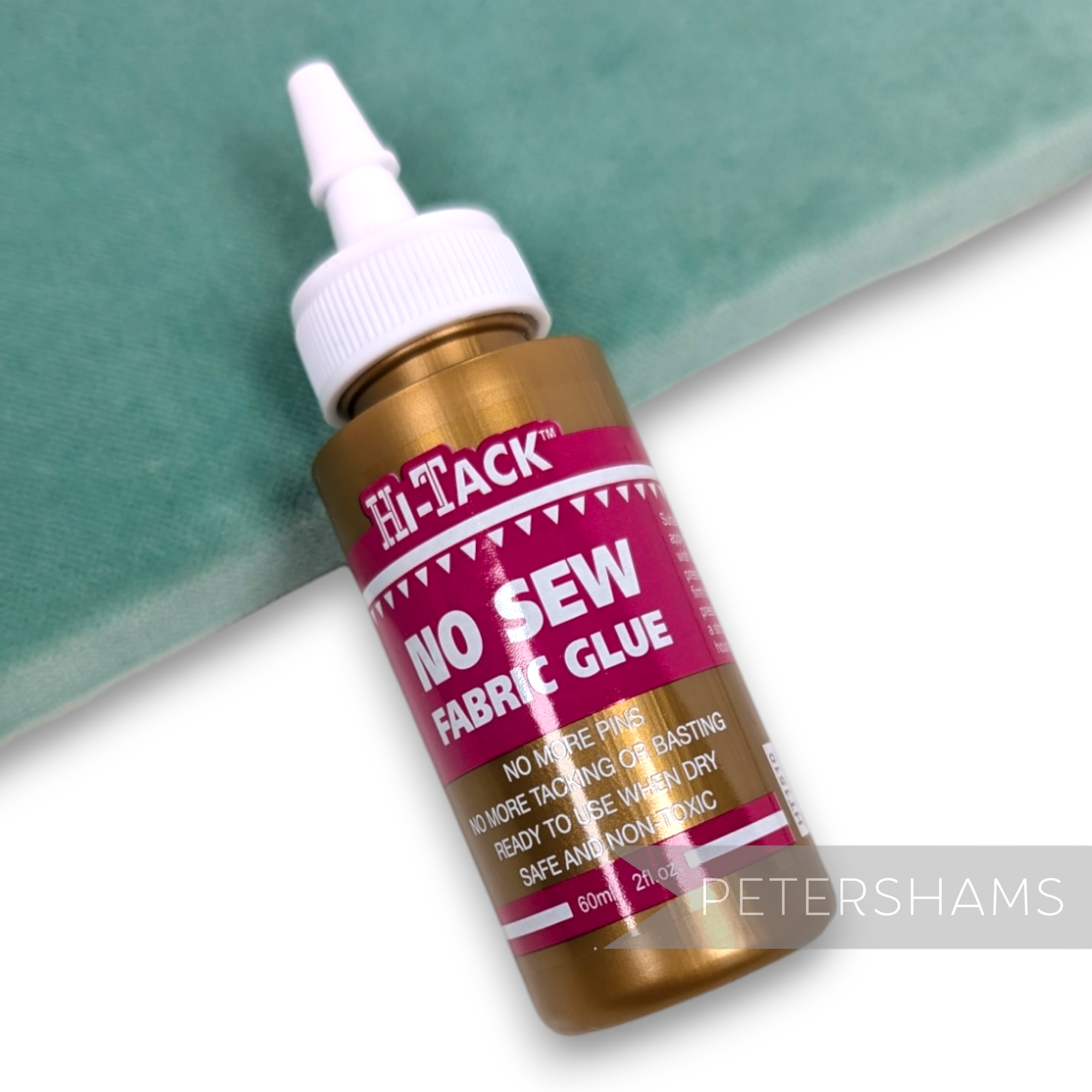Petershams Millinery Supplies 60ml Hi-Tack no-sew fabric glue tube with applicator tip on a green velvet background