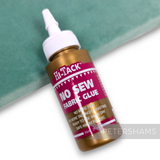 Petershams Millinery Supplies 60ml Hi-Tack no-sew fabric glue tube with applicator tip on a green velvet background