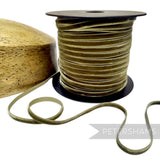 Petershams Millinery Supplies 7mm sage green French velvet ribbon on a spool next to a wooden hat block