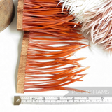 Petershams Millinery Supplies orange goose biot feather fringe on a satin ribbon binding with a measuring tape