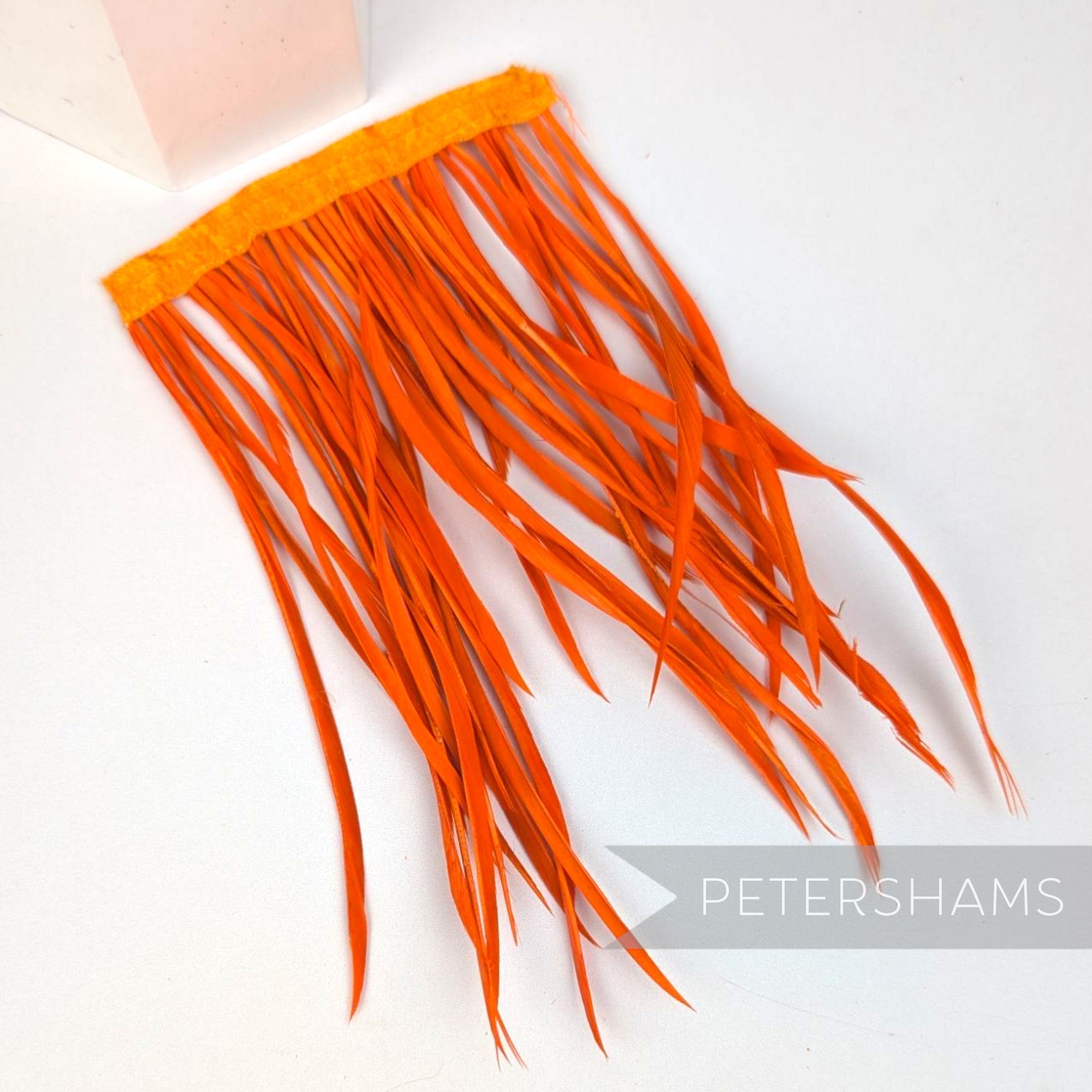 Petershams Millinery Supplies extra long orange goose biot feather fringe on a satin ribbon binding