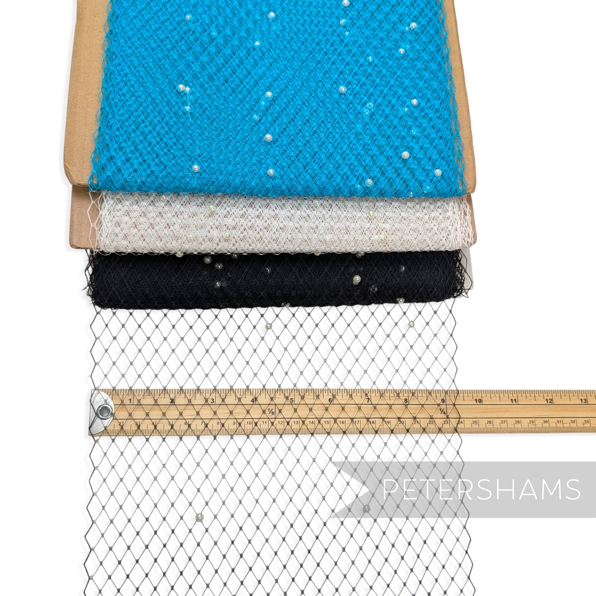 Petershams Millinery Supplies ivory pearl embellished veiling fabric rolls in blue, white, and black with ruler
