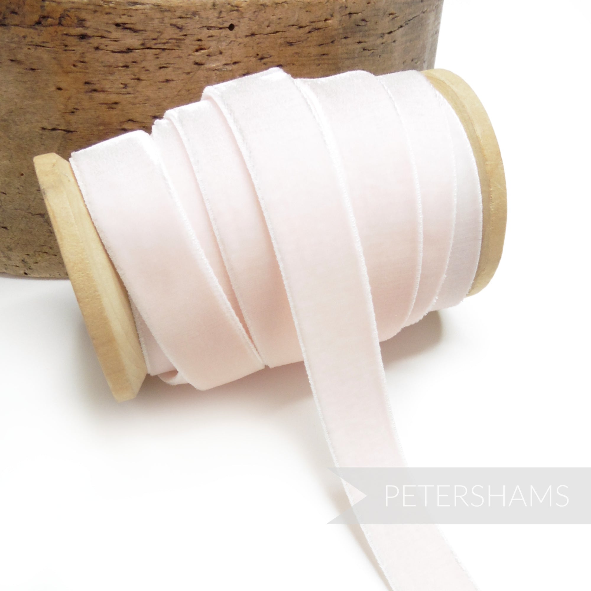 Petershams Millinery Supplies 16mm pale pink elastic stretch velvet ribbon on a wooden spool for millinery projects.