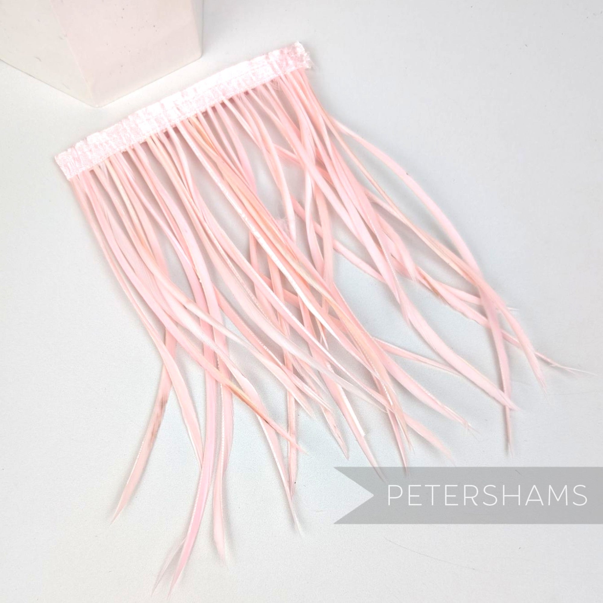 Petershams Millinery Supplies extra long pale pink goose biot feather fringe on a stitched satin ribbon binding