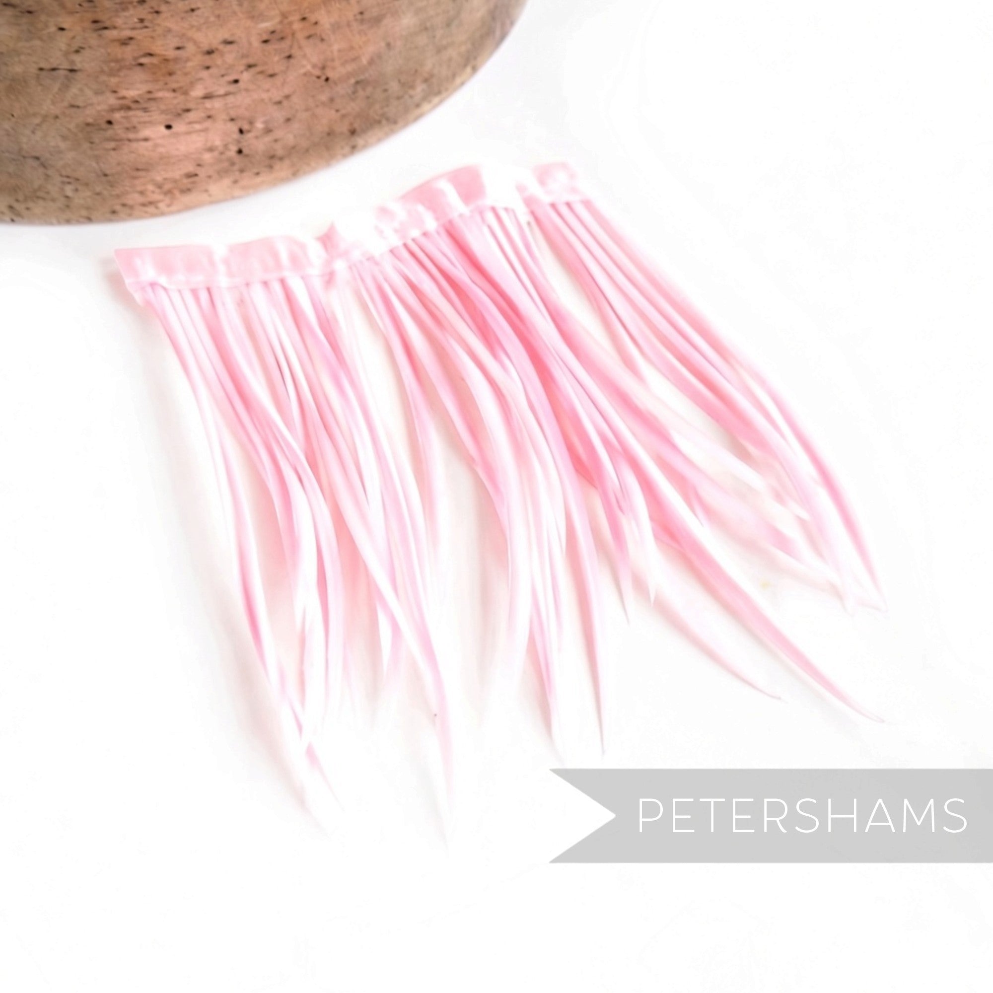 Petershams Millinery Supplies light pink goose biot feather fringe attached to a satin ribbon binding
