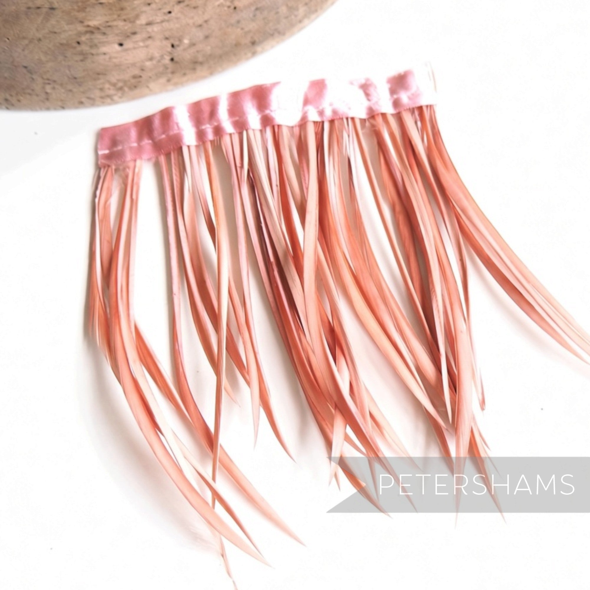 Petershams Millinery Supplies goose biot feather fringe in a soft dusty pink attached to a satin ribbon binding