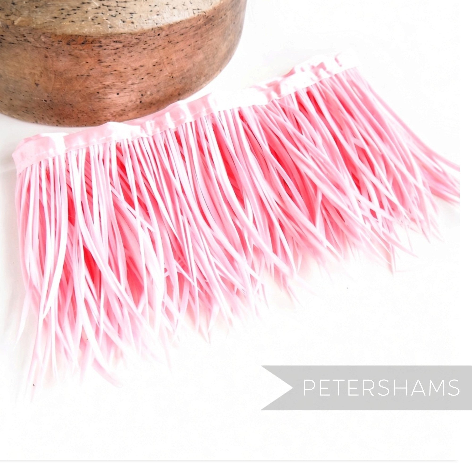 Petershams Millinery Supplies pink goose biot feather fringe attached to a satin ribbon binding for millinery crafts.
