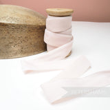 Petershams Millinery Supplies 24mm wide vintage pale pink rayon velvet ribbon on a wooden spool next to a hat block.