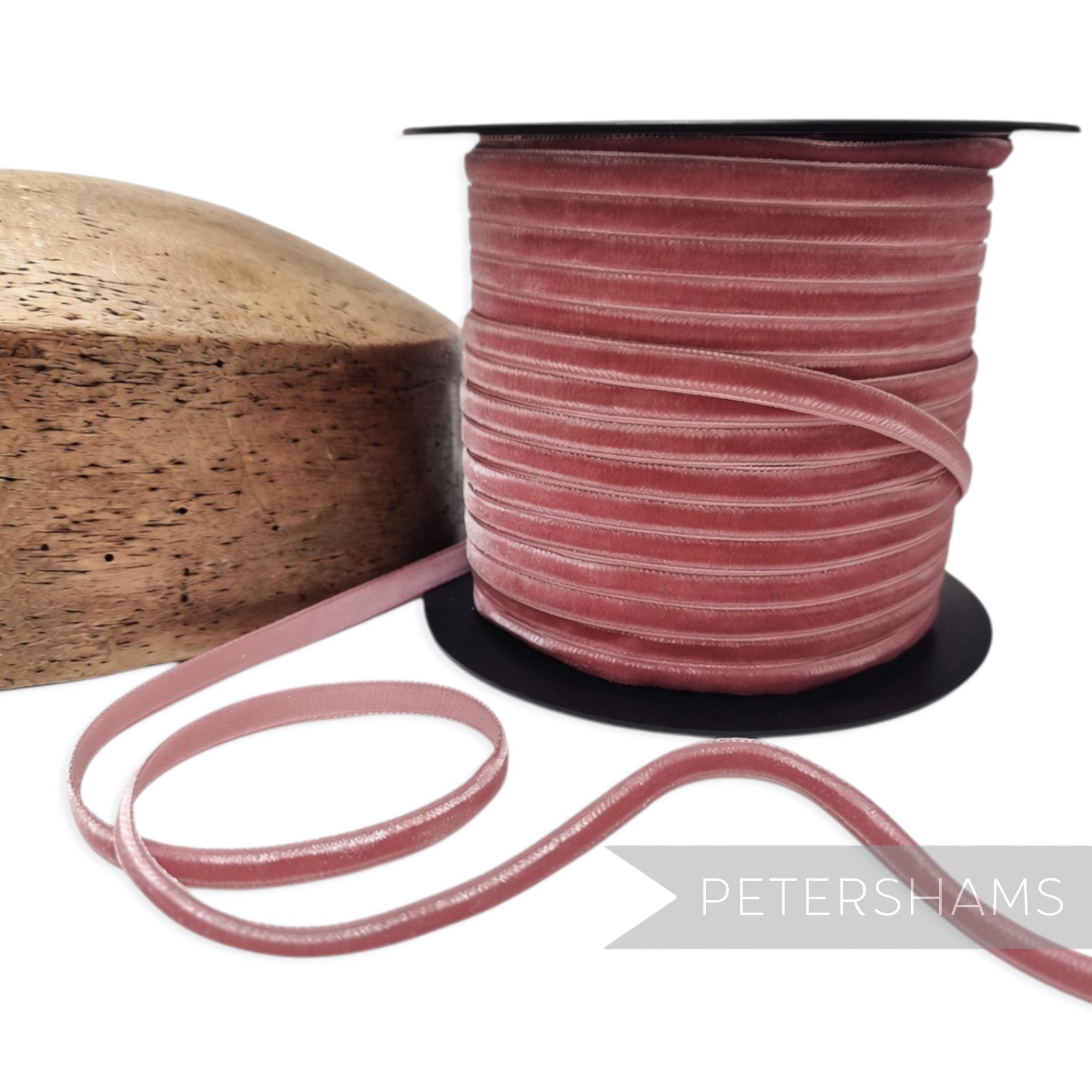 Petershams Millinery Supplies 7mm dusty pink French nylon velvet ribbon on a spool next to a wooden hat block
