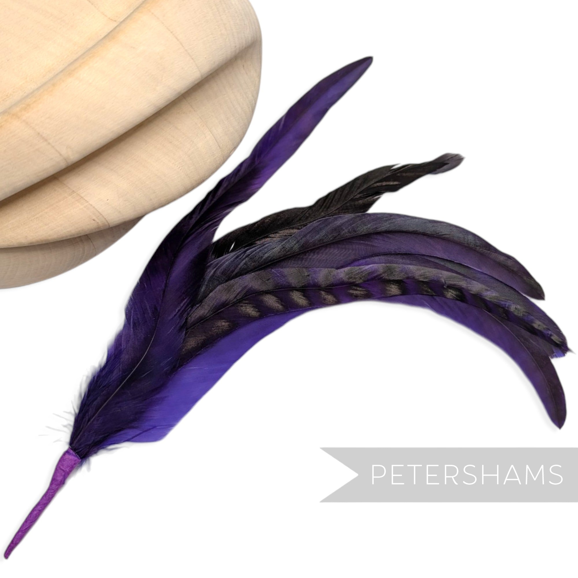 Petershams Millinery Supplies purple chinchilla full coque feather hat mount with 6 striped feathers on a wired stem.