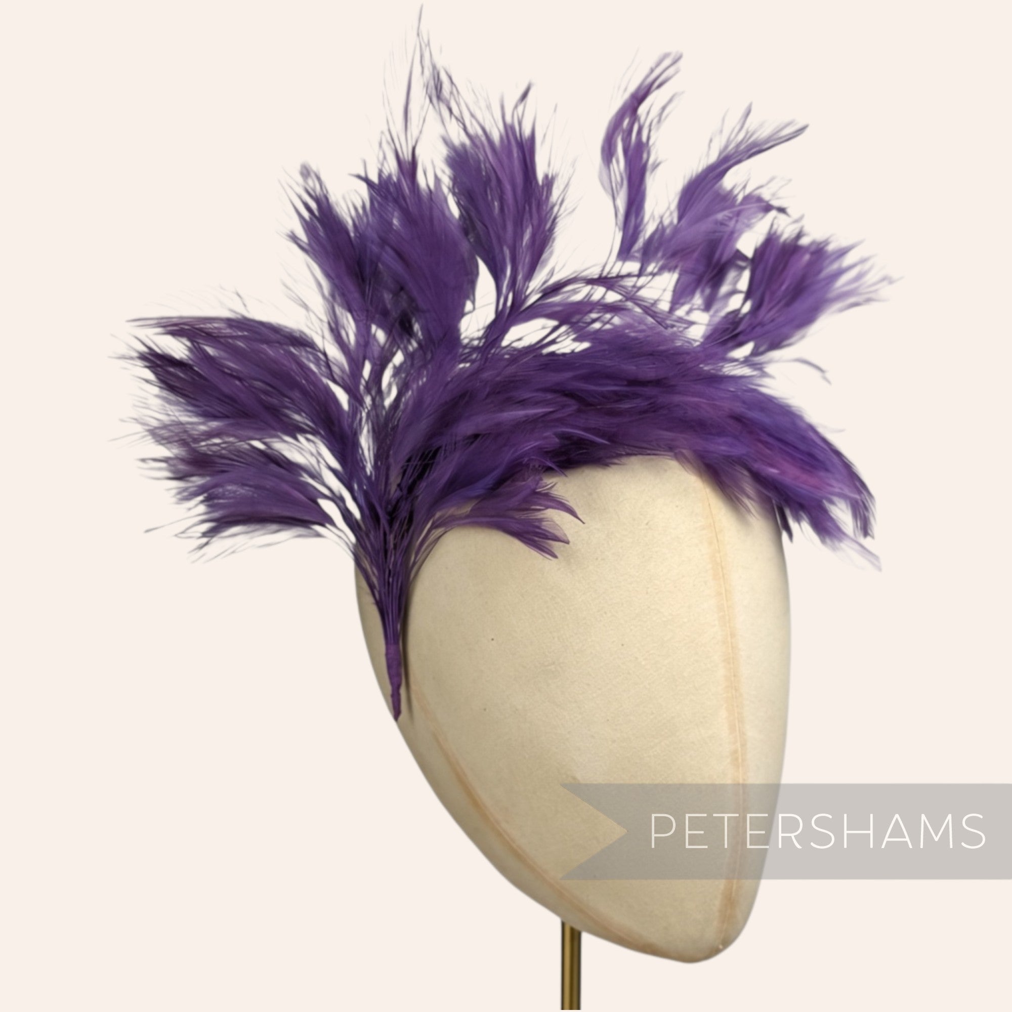 Petershams Millinery Supplies large purple stripped hackle wired feather hat mount on a millinery head block