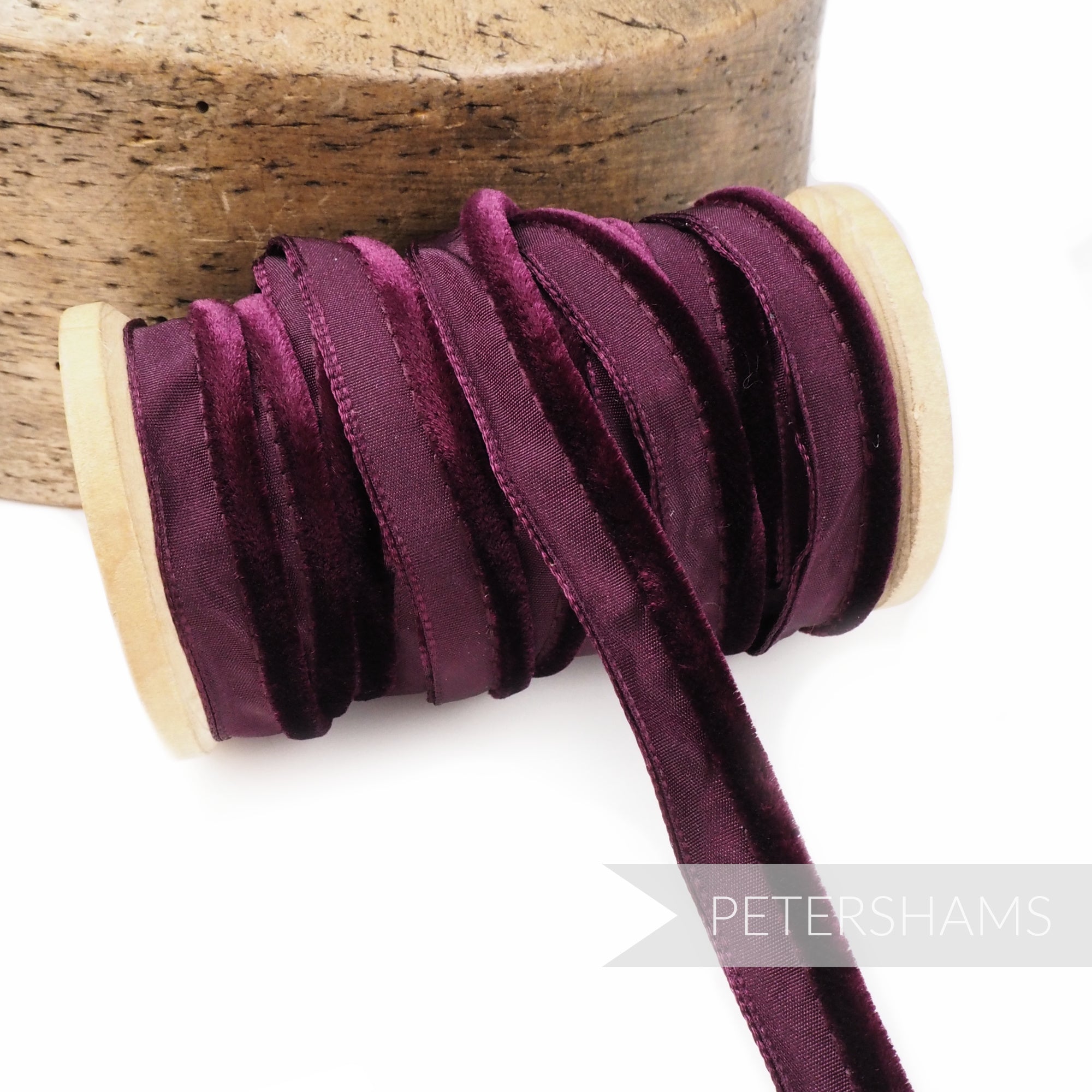 Petershams Millinery Supplies 5mm deep purple velvet insertion piping cord on a wooden spool for sewing and millinery.