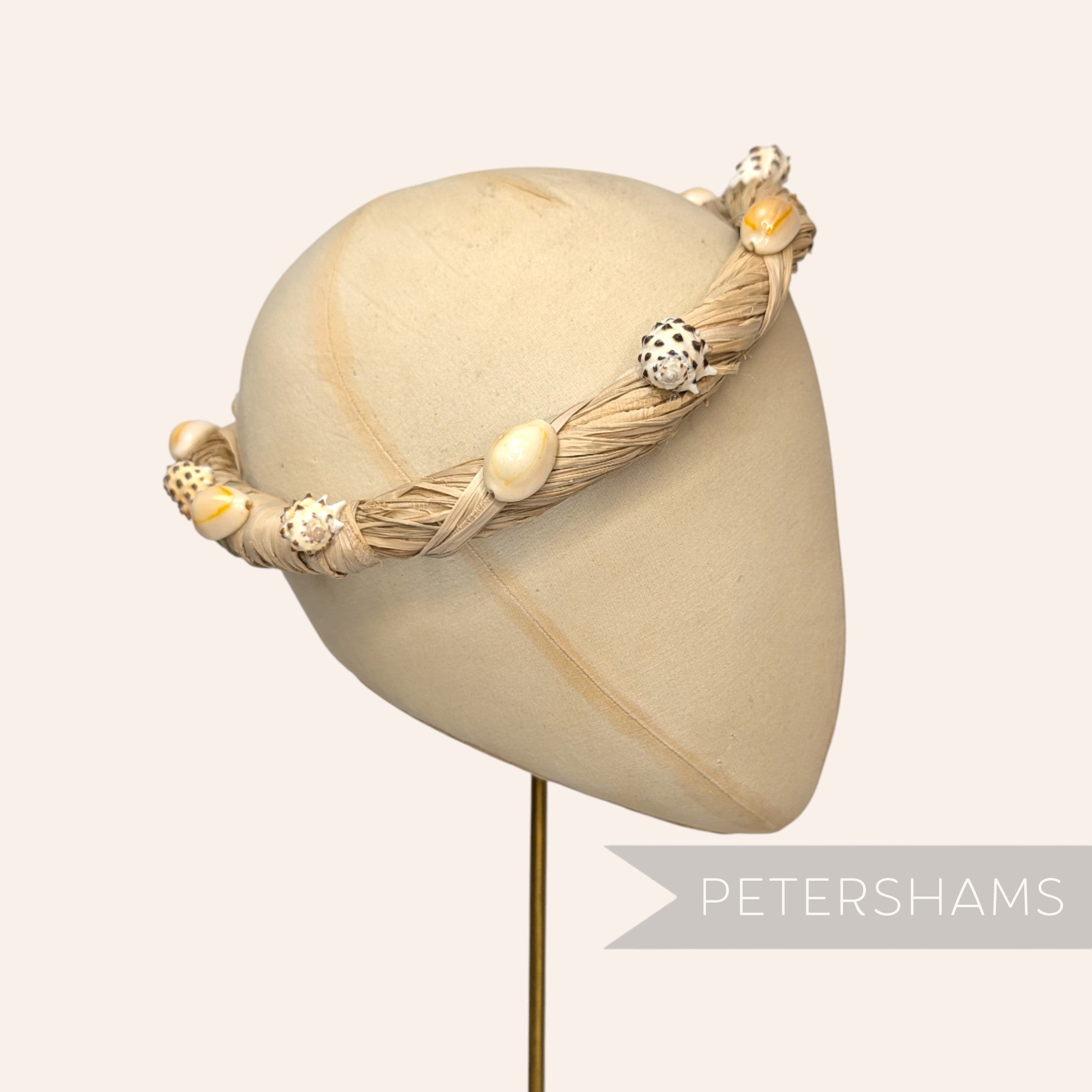 Petershams Millinery Supplies natural raffia headdress frame adorned with assorted seashells.