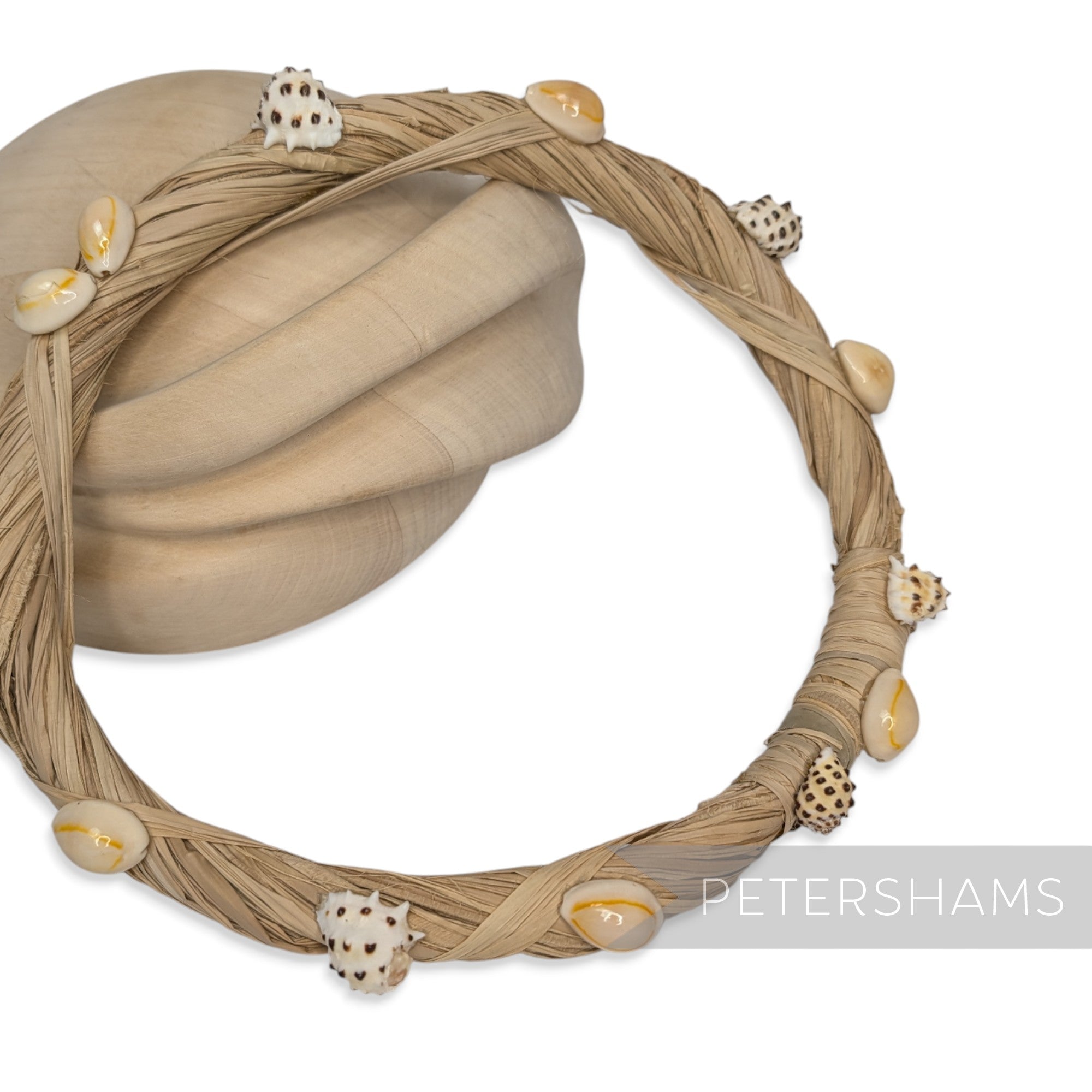 Petershams Millinery Supplies natural raffia headdress frame decorated with assorted seashells.