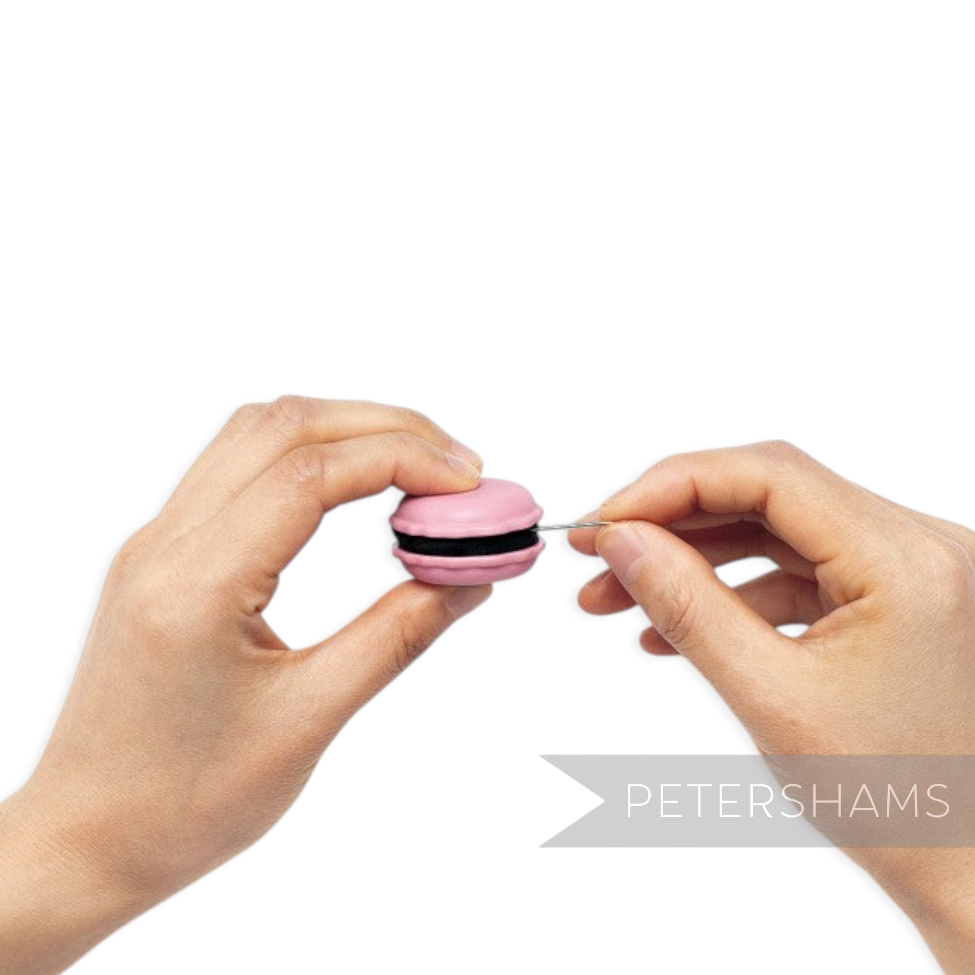 Petershams Millinery Supplies raspberry pink macaron needle minder and sharpener being used to sharpen a needle