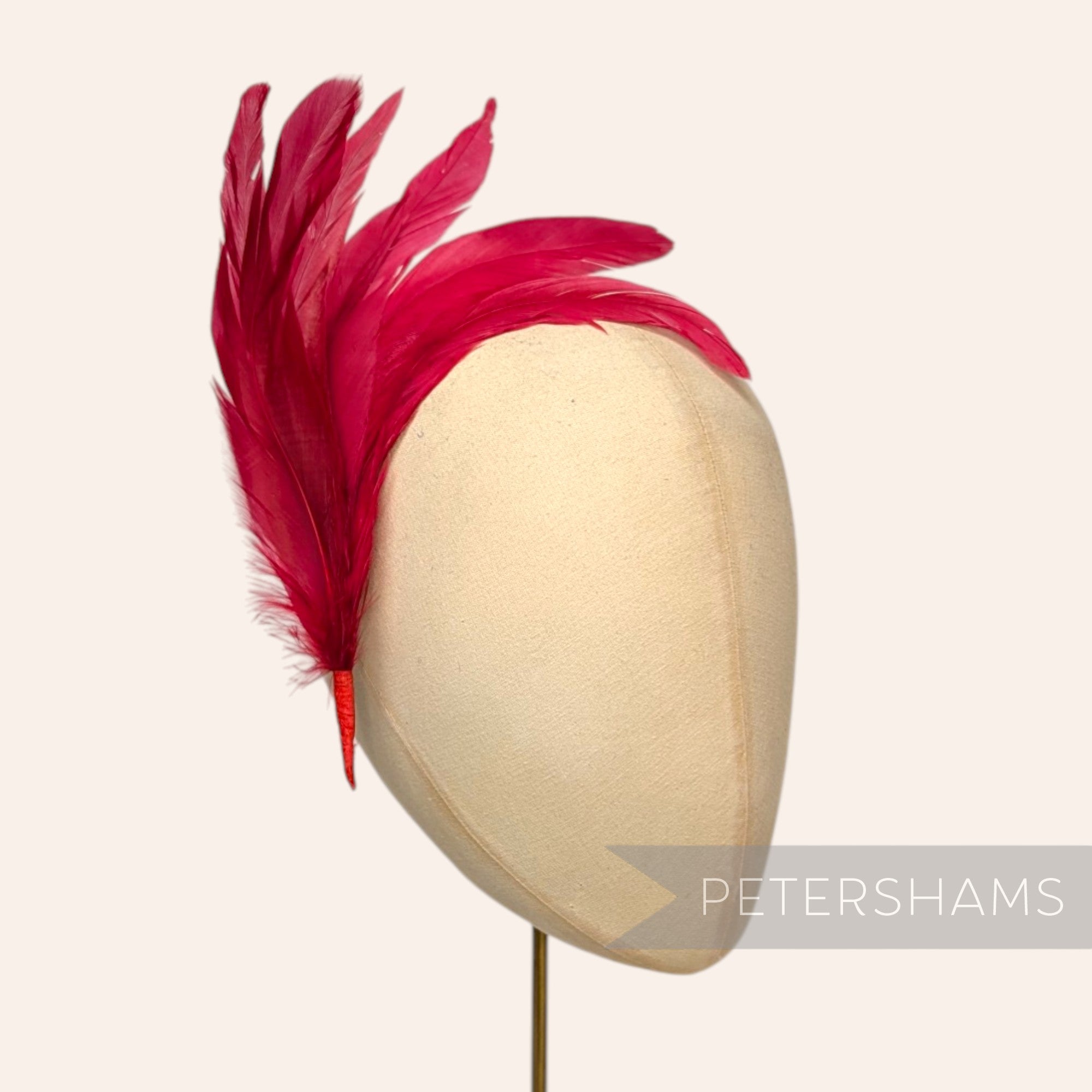 Petershams Millinery Supplies red full coque feather hat mount with six lush feathers on a wired stem.