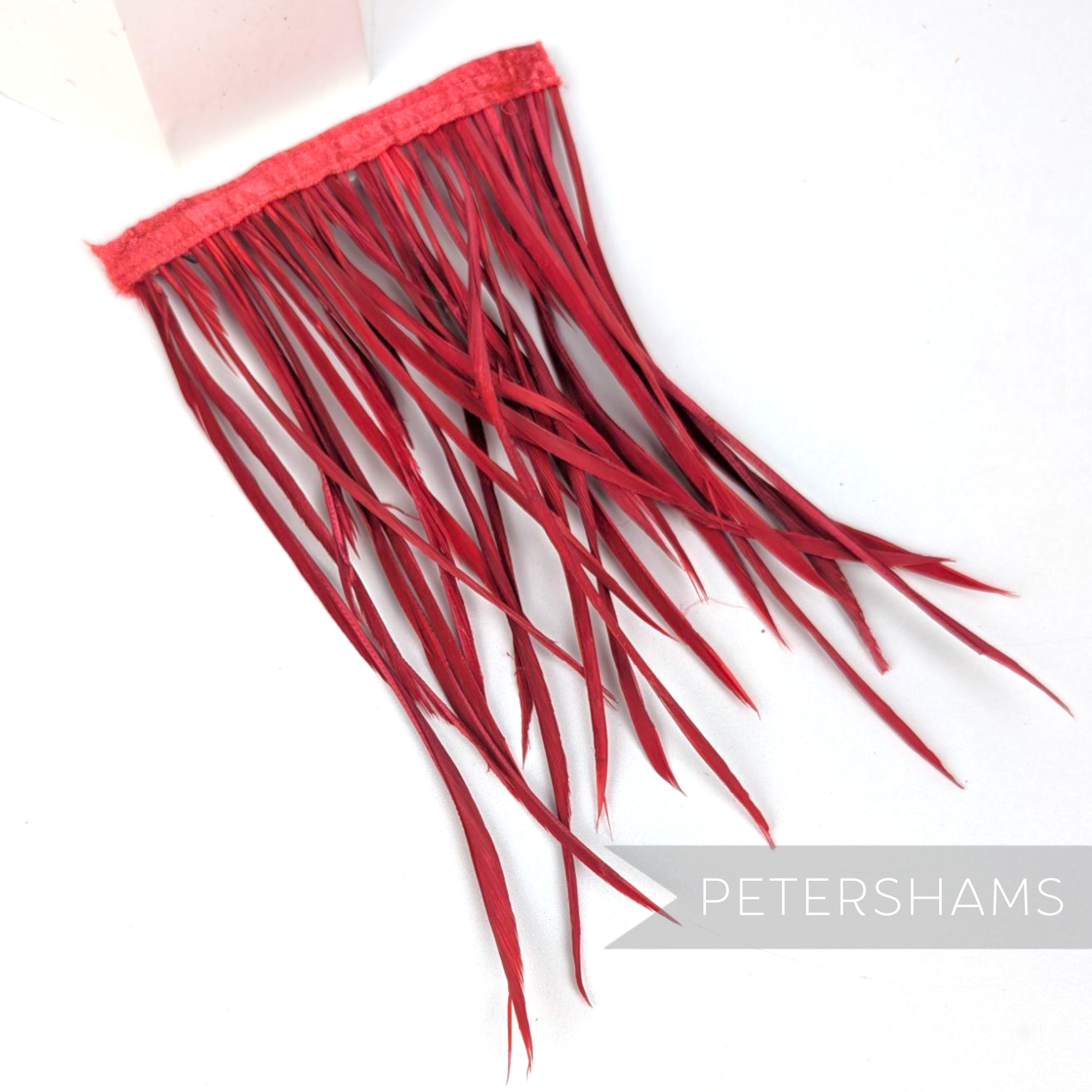 Petershams Millinery Supplies extra long red goose biot feather fringe on a satin ribbon binding