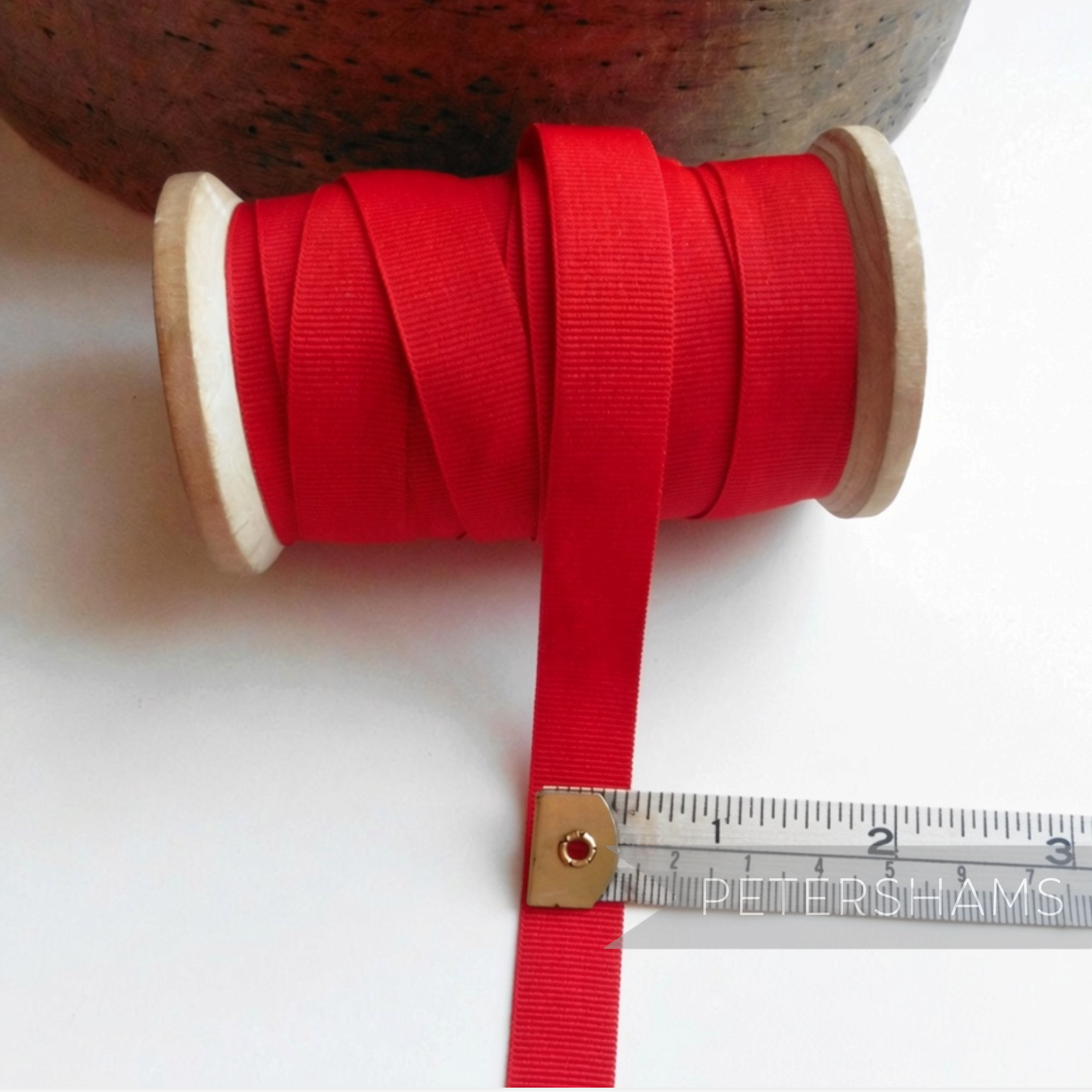 Petershams Millinery Supplies vintage 15mm wide red grosgrain ribbon on a wooden spool with a measuring tape.
