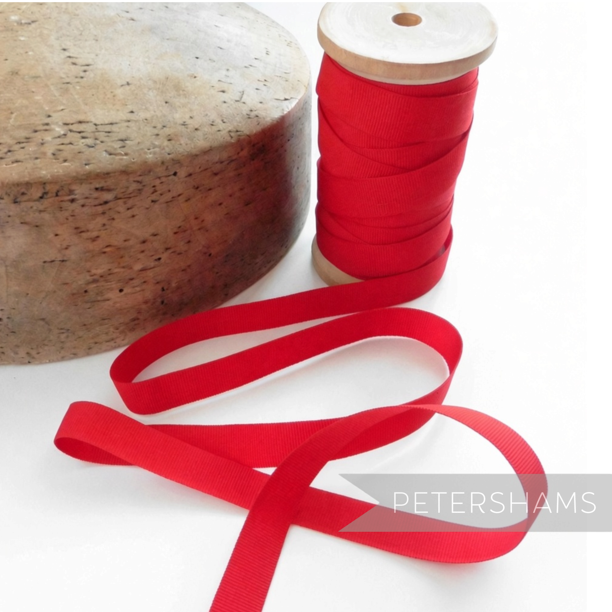 Petershams Millinery Supplies vintage 15mm wide red grosgrain ribbon on a wooden spool next to a hat block