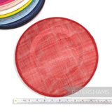 Petershams Millinery Supplies red 29cm round sinamay fascinator hat base with a stack of other colours in background