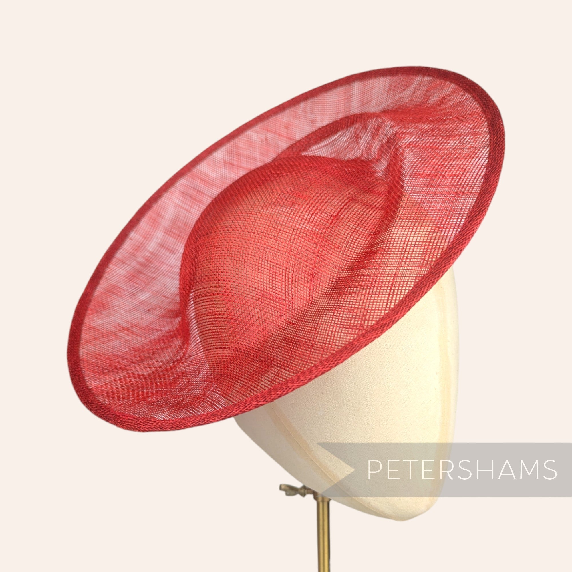 Petershams Millinery Supplies poppy red sinamay fascinator hat base with orbital pleat design on a mannequin head