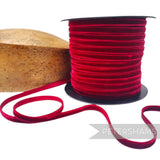 Petershams Millinery Supplies 7mm red French velvet ribbon on a spool next to a wooden millinery block