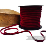 Petershams Millinery Supplies 7mm deep red French velvet ribbon on a spool next to a wooden millinery block.