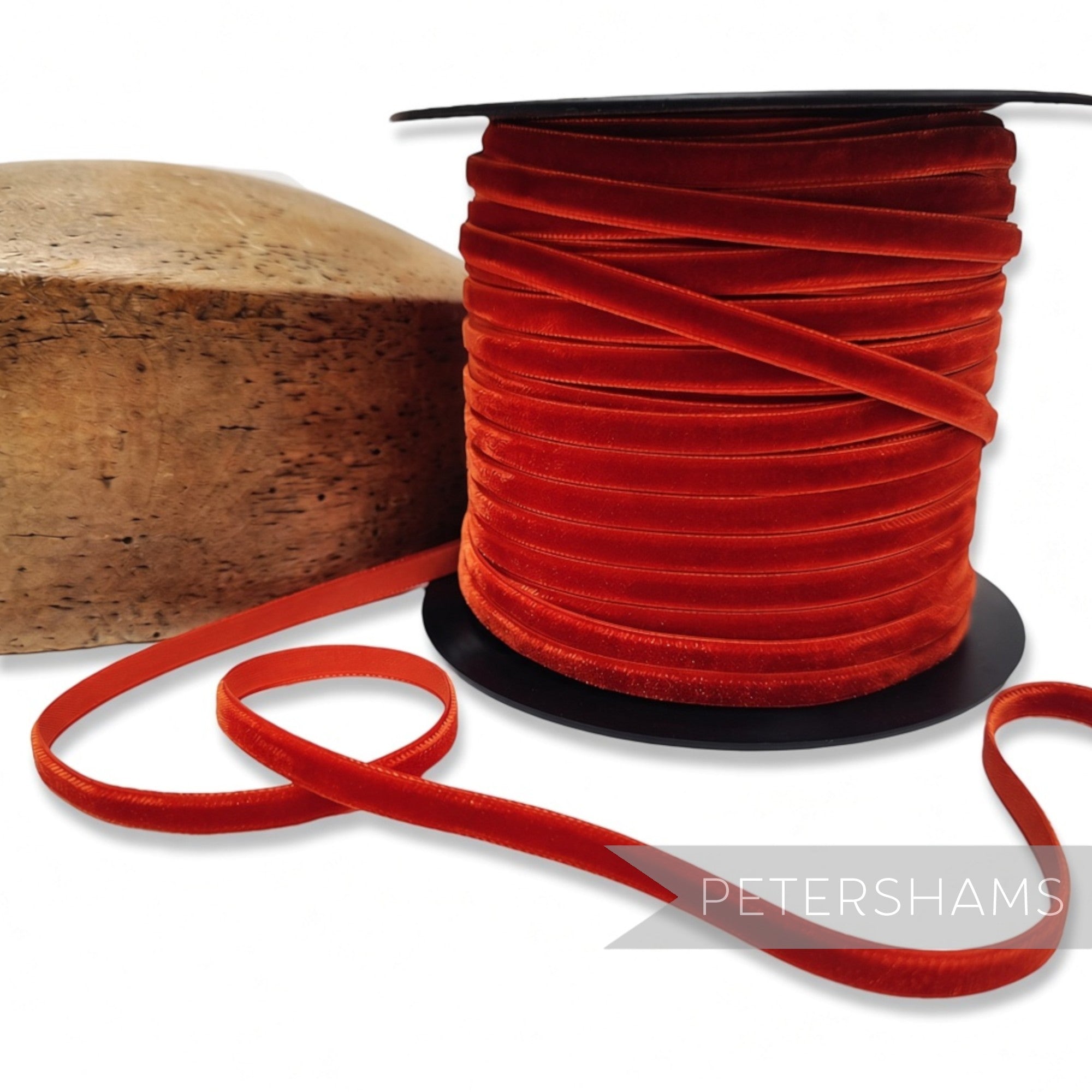 Petershams Millinery Supplies 7mm auburn French velvet ribbon on a spool next to a wooden millinery block