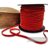 Petershams Millinery Supplies 7mm auburn French velvet ribbon on a spool next to a wooden millinery block