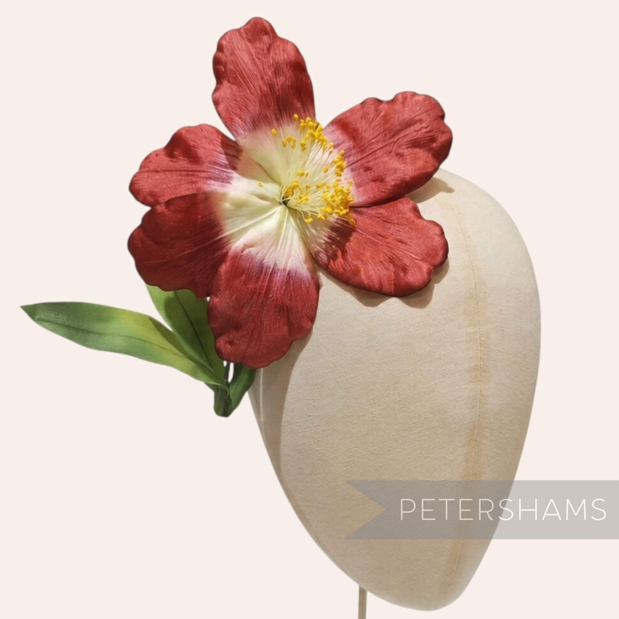 Petershams Millinery Supplies vintage German silk hibiscus flower in rust with yellow stamens on a millinery head